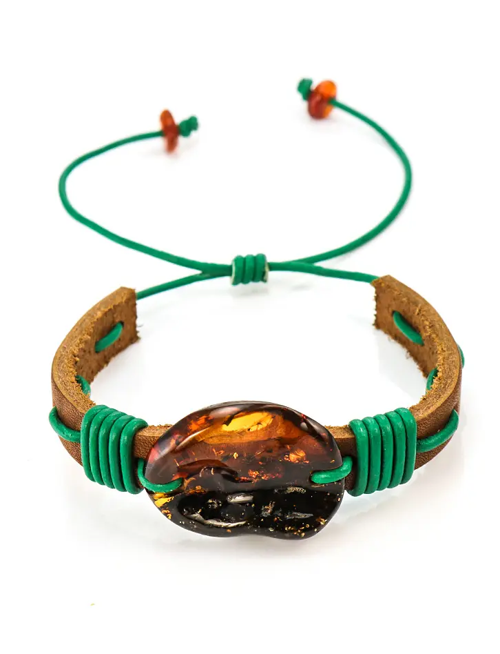 картинка Стильный браслет «Копакабана» из коричневой кожи, переплетённой зелёным шнурком с крупным коньячным янтарём в онлайн магазине